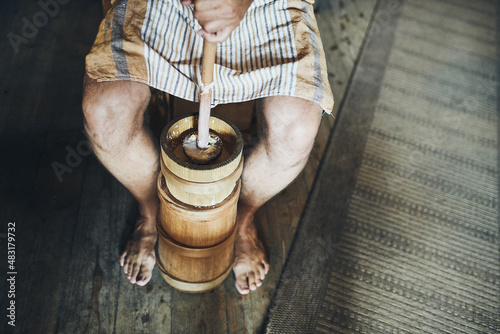 Photography Man making butter with butter churn