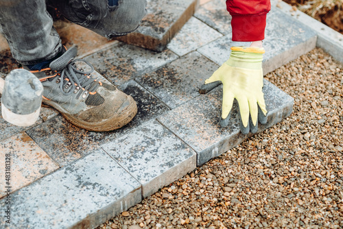 Portrait of bricklayer laying slabs and pavement in garden