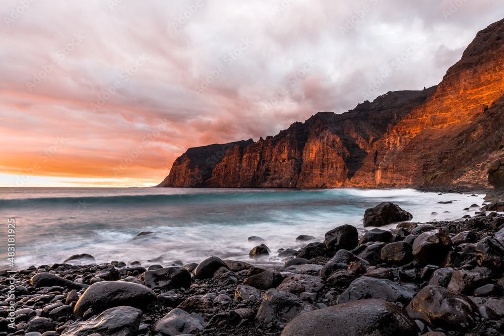 Multi colored sunset over los Gigantes cliffs from playa de los Guíos, tenerife spain landmark.