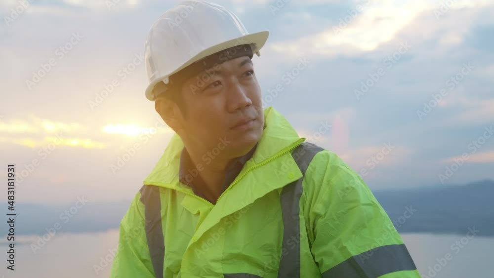 a man engineer is putting a protective helmet on her head at sunset.. a man engineer is putting a protective helmet on her head at sunset..