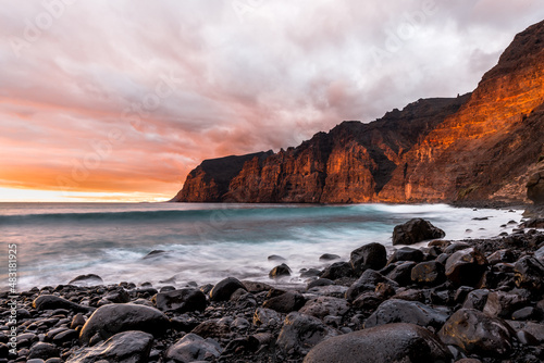 Multi colored sunset over los Gigantes cliffs from playa de los Guíos, tenerife spain landmark.
