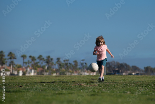 Boy child playing football on football field. Kid playing soccer. Kids training soccer.