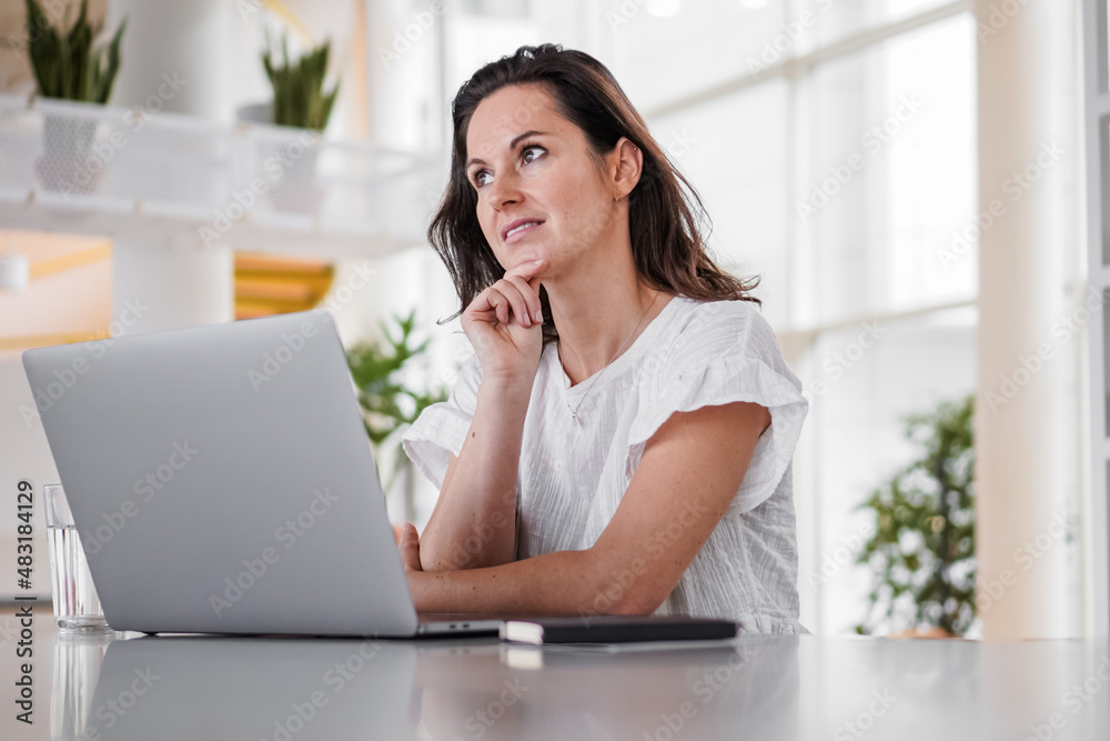 thoughtful brooding remote working dark haired woman sitting infront of a laptop or notebook in casual outfit on her work desk in her modern airy bright living room home office with many windows
thoughtful brooding remote working dark haired woman sitting infront of a laptop or notebook in casual outfit on her work desk in her modern airy bright living room home office with many windows