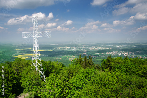 A large white cross atop Mount Chełmiec during a sunny summer day, with the city of Wałbrzych in the backgroud, Wałbrzyskie Mountains, Central Sudetes, Poland photo