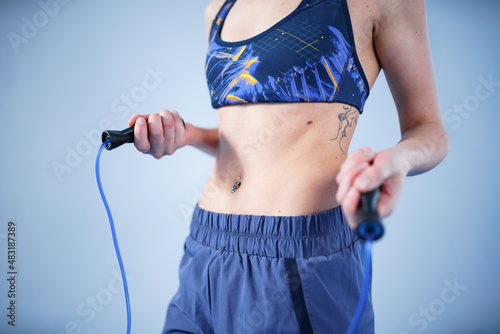 Smiling sportswoman posing with a skipping rope. Female with muscular body posing with jump rope. Fitness model. Body positivity, sport, fitness concept. Healthy lifestyle. Fit woman with jump rope