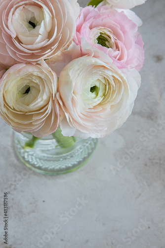 Bouquet of soft pink ranunculus flowers in a glass vase top view