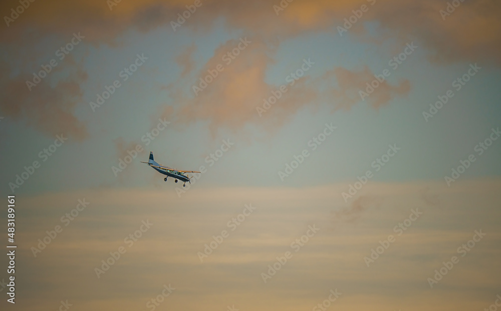 Cessna 208b Grand Caravan G-CPSS light aircraft returning to land, moody sunset sky