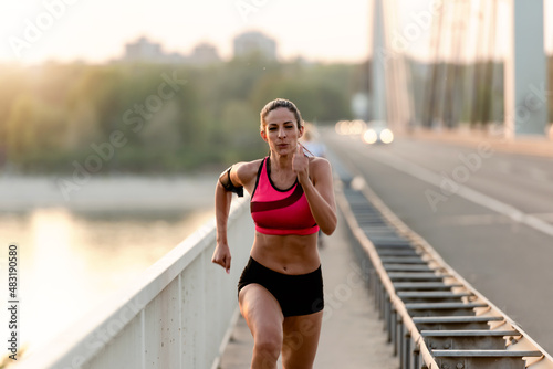 Young fitness woman jogging outdoors in the city over the bridge © lordn