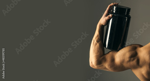 Fototapeta Naklejka Na Ścianę i Meble -  Taking vitamins for a healthy diet. Muscular man with vitamin supplements. Strong man hold supplement bottle. Bodybuilding sport and fitness. Vitamin diet and sport nutrition. Sport diet