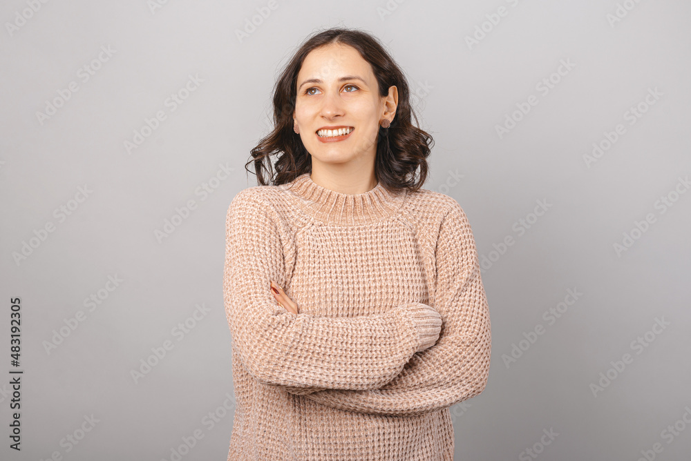 Portrait of a dreaming girl. Crossed arms portrait over gray background. Portrait of a dreaming girl. Crossed arms portrait over gray background.