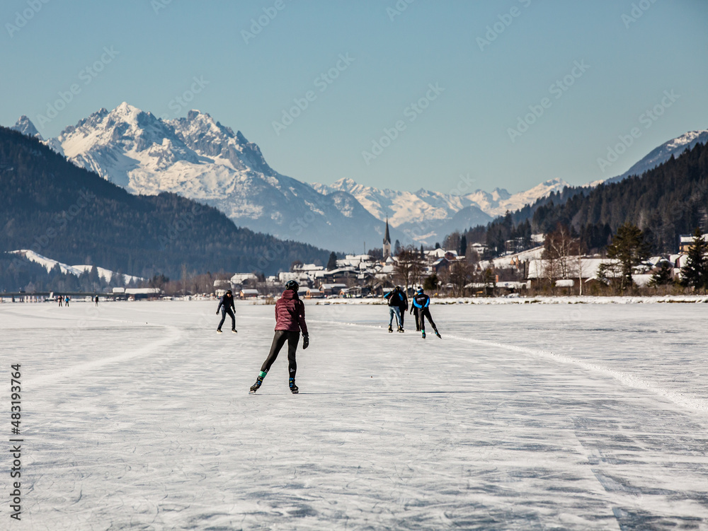 skaters on a frozen lake at the White lake (in German Weissensee)