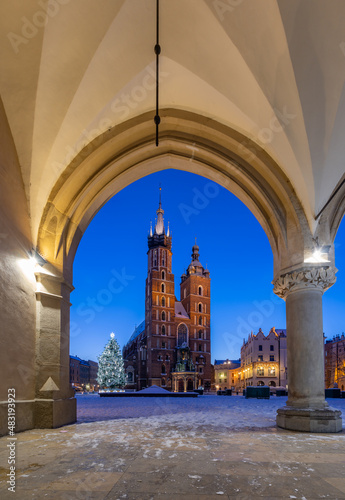 St Mary's church on snow covered Main Square seen form Cloth Hall arcades in winter Krakow, Poland