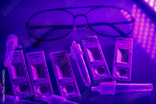5 covid-19 antigen self-tests positive, buffer bottles and thin black-rimmed glasses on a light background. Self test. test at home. Corona, Covid 19, coronavirus SARS-CoV-2 flu disease pandemic photo