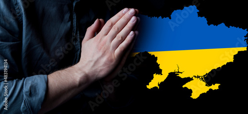 Hands in prayer. Prayer for Ukraine. Ukrainian flag. Prayer for the whole world. Europe and America. War in Ukraine. photo