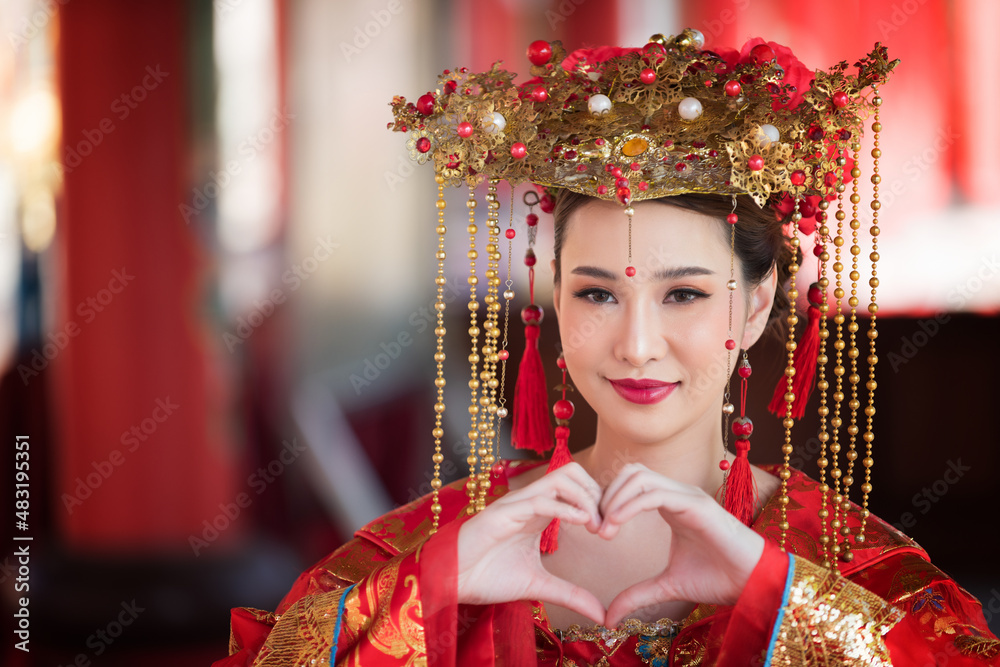 Asian young beautiful woman, She eye look in Chinese dress fashion with holding fan in Chinese new year festival.