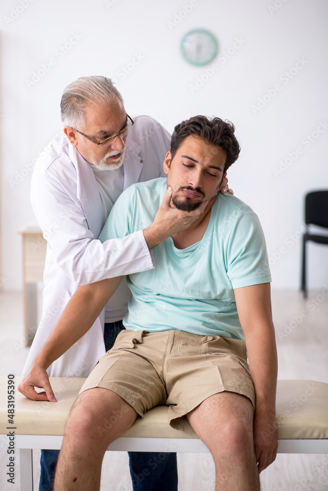 Obraz premium Young male patient visiting old male doctor