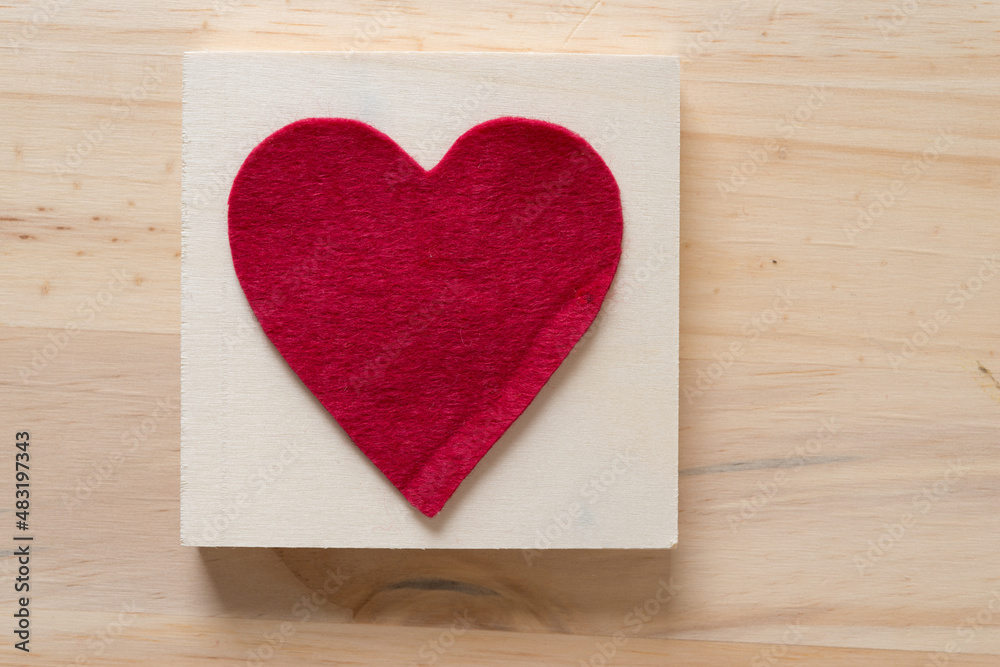 isolated felt heart on the back of a wooden box, sitting on a wooden surface isolated felt heart on the back of a wooden box, sitting on a wooden surface