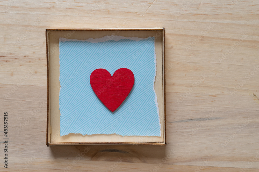 red heart isolated in a box with blue paper and wood red heart isolated in a box with blue paper and wood