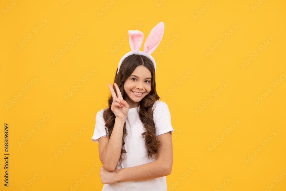 cheerful child in bunny ears on yellow background show peace, easter cheerful child in bunny ears on yellow background show peace, easter