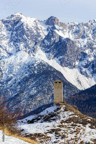 Ruins Steinsberg from the ancient Medieval Castle Steinsberg over the Swiss Alp village Ardez with snow mountain at the background in Engadin valley, Graubunden canton, Switzerland