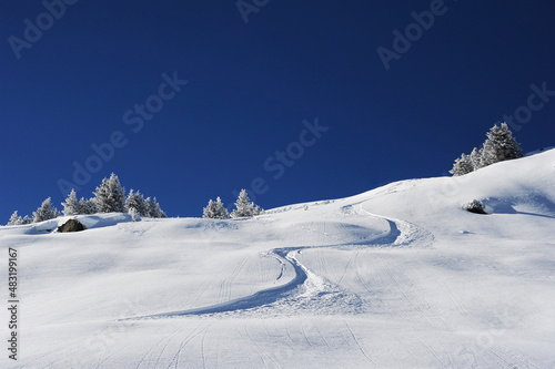 Ski track on a ski resort slope on fresh snow with no people 