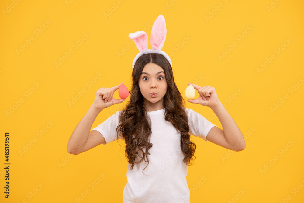 funny cheerful kid in bunny ears hold eggs on yellow background, happy easter funny cheerful kid in bunny ears hold eggs on yellow background, happy easter