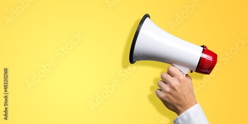 A human's hand holding a megaphone. Creative announcement concept. Loud voice