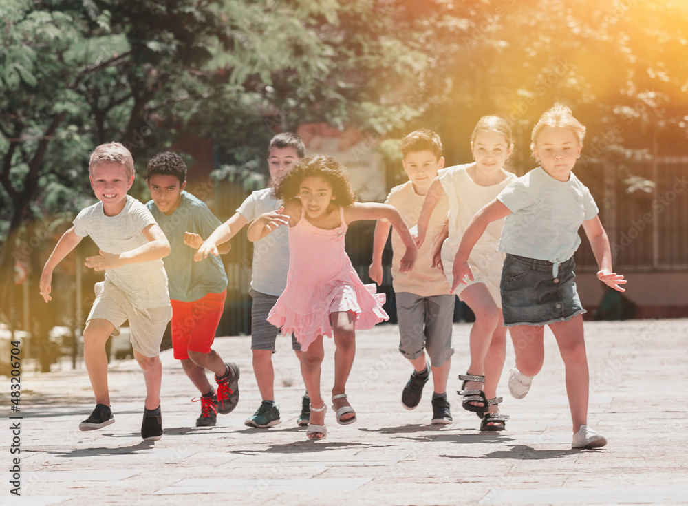 Happy children running in race and laughing outdoors at sunny day