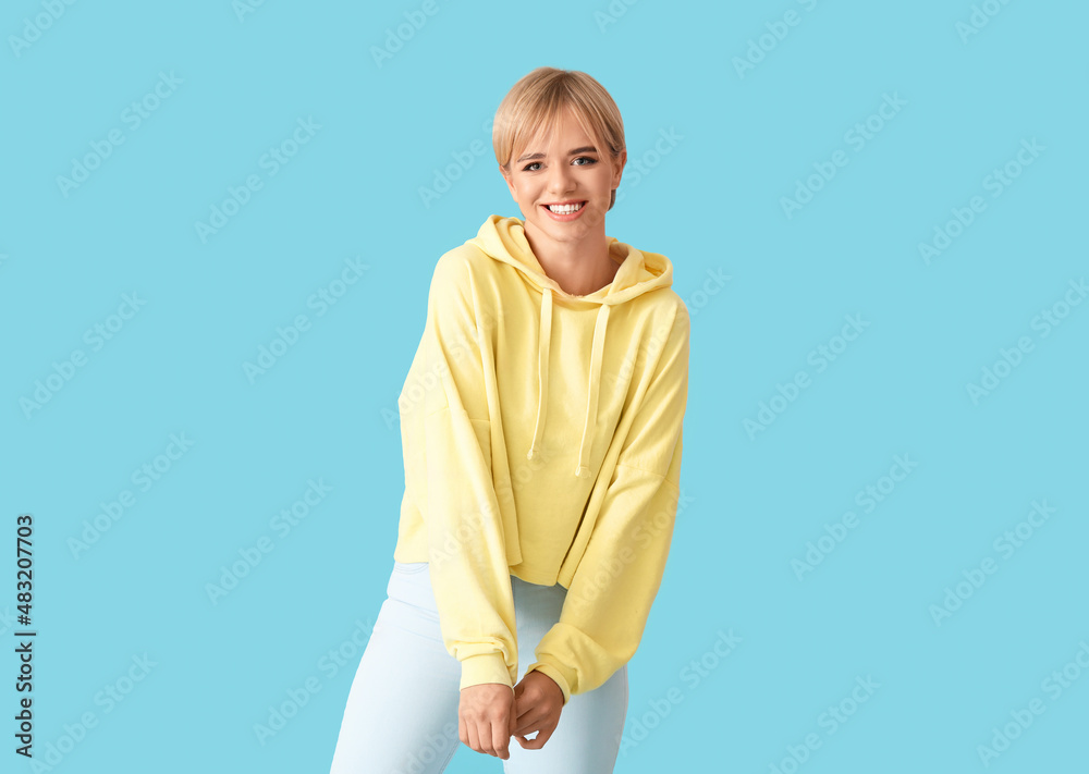 Beautiful young woman in stylish hoodie on color background Beautiful young woman in stylish hoodie on color background
