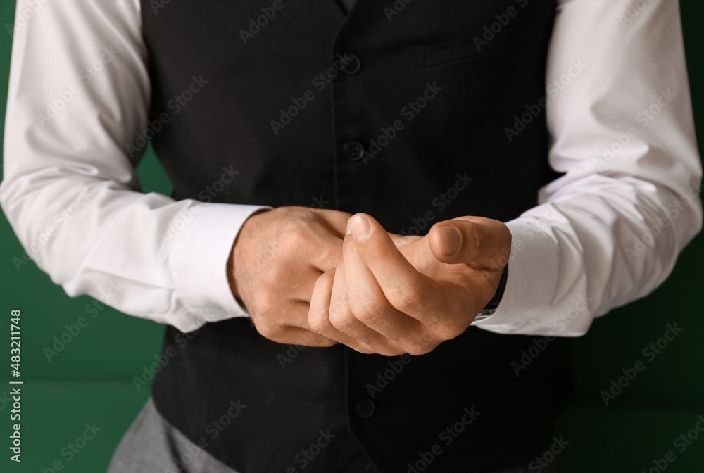Gentleman in stylish clothes adjusting sleeve on color background, closeup