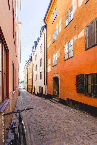 Bright sun reflections on narrow street in historic part of Stockholm. Old fashioned building in Gamla stan. Sweden.