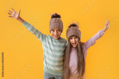 Happy little children in winter clothes on color background © Pixel-Shot
