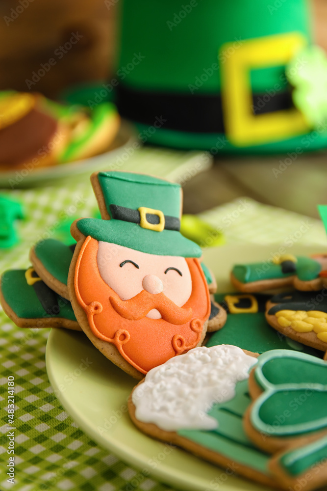Plate with tasty gingerbread cookies for St. Patrick's Day celebration on table, closeup