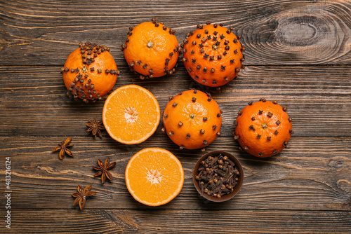 Handmade Christmas decoration made of tangerines with cloves on wooden background