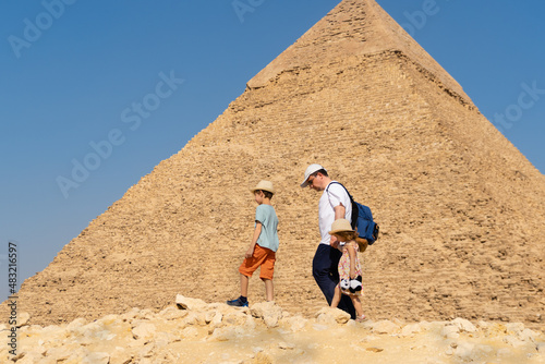 Father and children walk in front of the Chephren pyramid on the Giza plateau