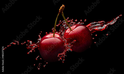 Valokuva red cherries in red juice splash on a black background