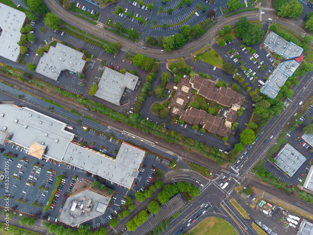 Shooting from the air. Suburb. Asphalt roads, parking lots, lots of greenery. Roofs of one-story houses. Planning, map, topography, ecology, construction, tourism, travel.
