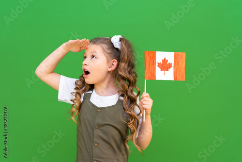A Canadian flag in the hands of a little girl on an isolated background. moving to Canada and getting an education.
