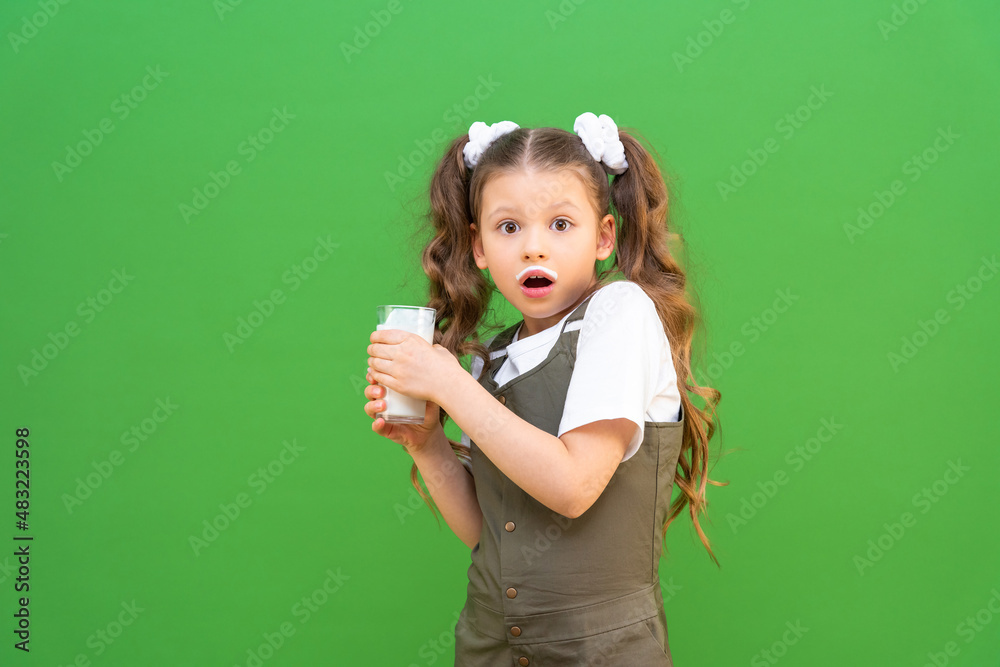 A child with a glass of kefir is very surprised. Proper nutrition for children. Calcium for bone growth. A child with a glass of kefir is very surprised. Proper nutrition for children. Calcium for bone growth.