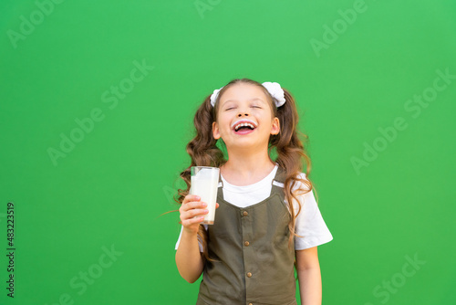 A glass of healthy cow's milk in the hands of a girl. Breakfast with dairy products. the benefits of calcium for humans.