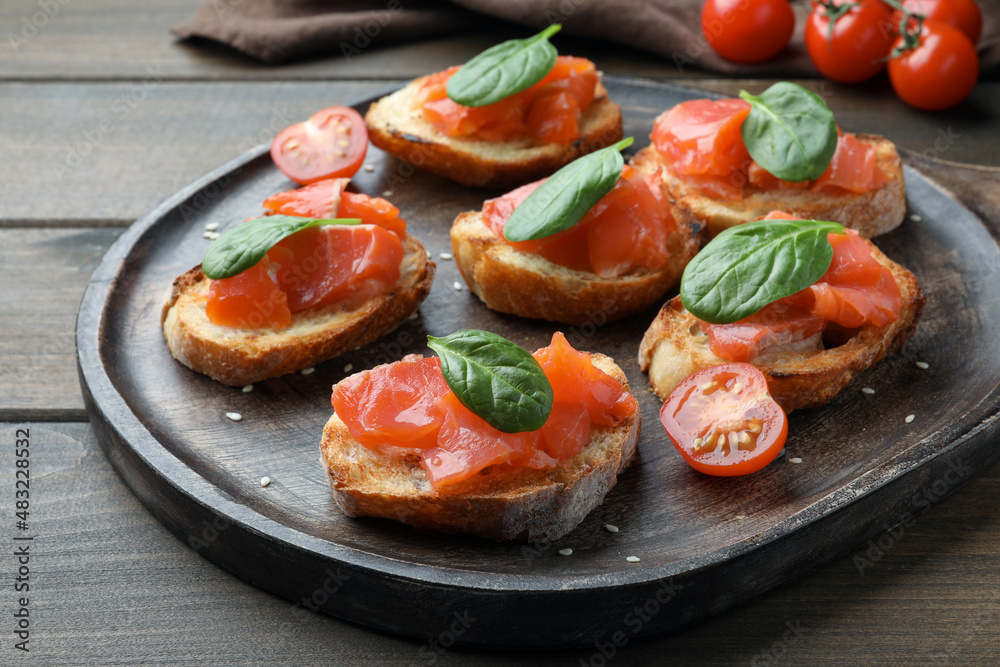 Delicious sandwiches with salmon and spinach on wooden table