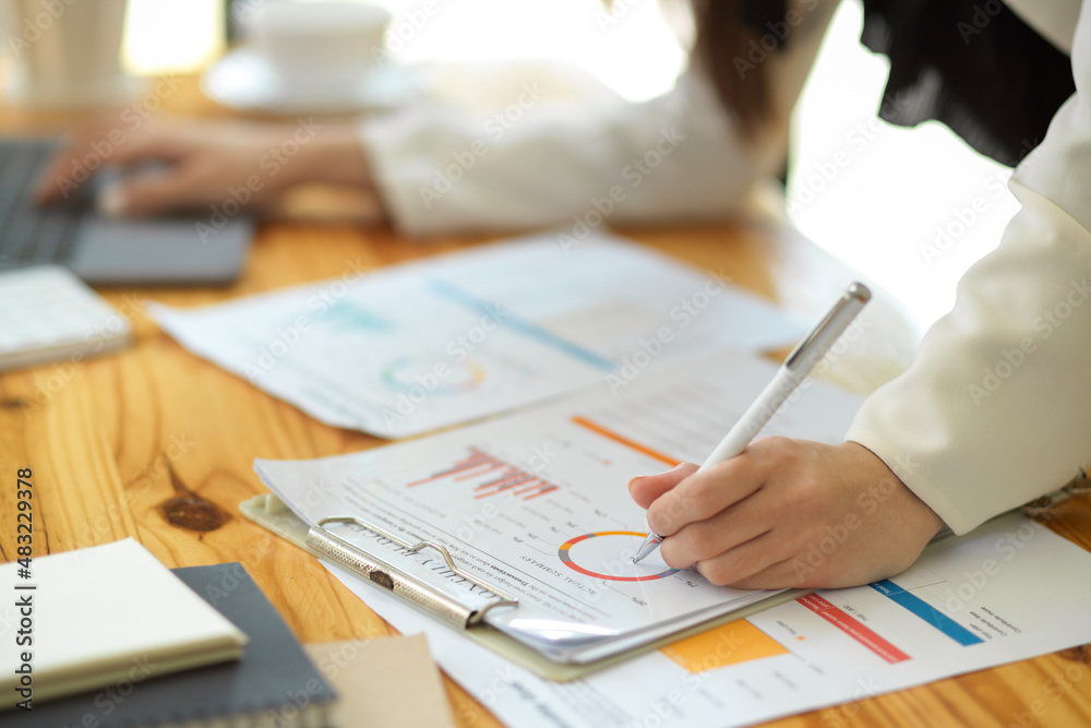 Close-up hand image, A female rechecks the financial report.