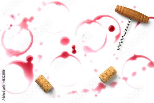 Red wine rings, drops, bungs and corkscrew on white background, top view