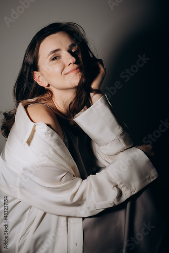 portrait of a fashionable young beautiful Ukrainian woman wearing a linen dress shirt in a studio