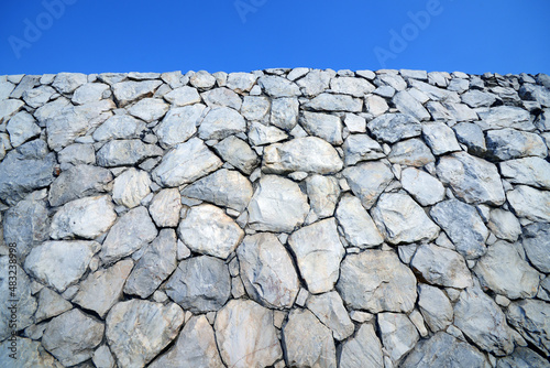 Stone wall background with blue sky