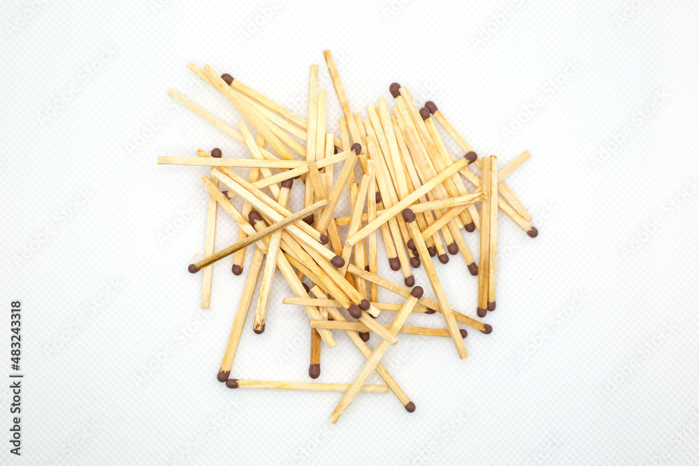 Wooden matches lie in a mountain, close-up. White background