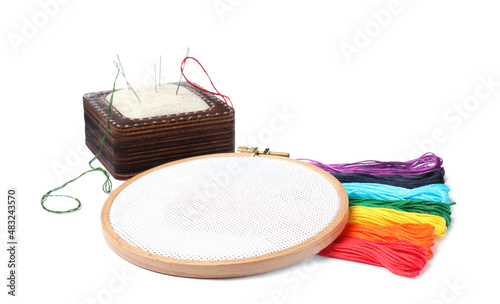 Colorful threads and different embroidery accessories on white background