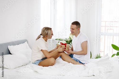 A young man gives his wife or girlfriend a gift for Valentine's day or anniversary