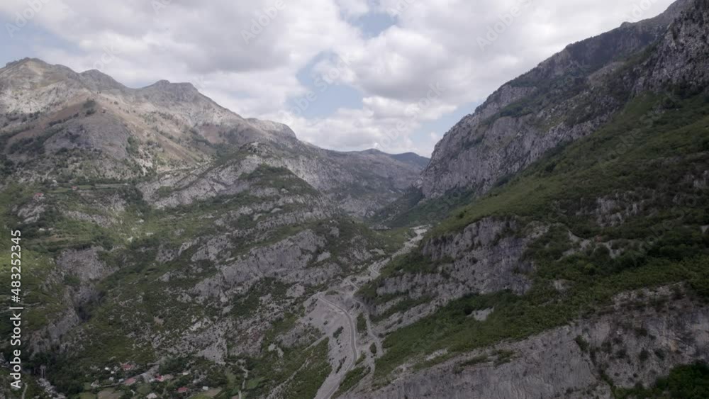 Drone video of frontal plane advancing on the Sh20 highway in Albania, at the height of Javor and Mreg, snake road, small houses of the town can be seen, cloudy sky Drone video of frontal plane advancing on the Sh20 highway in Albania, at the height of Javor and Mreg, snake road, small houses of the town can be seen, cloudy sky