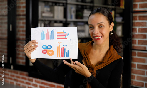 Portrait closeup shot of African American professional successful female businesswoman secretary in casual outfit standing smiling look at camera showing company analysis target graph chart report